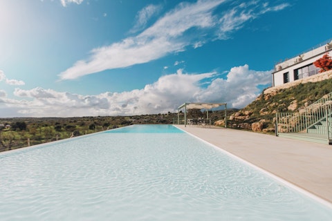Swim out towards rolling Sicilian countryside under open skies