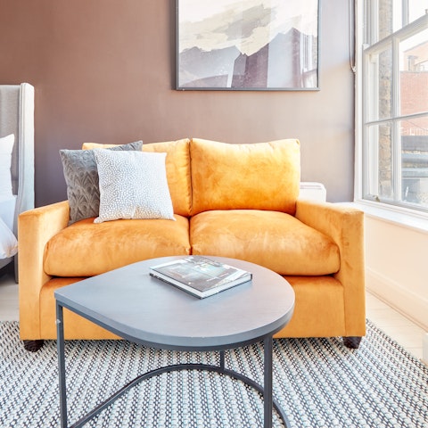 Relax with an art catalogue on the plumpy velvet sofa
