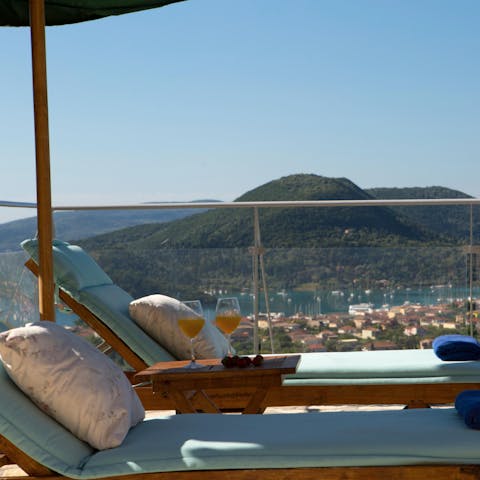 Relax on a sun lounger overlooking the Greek islands