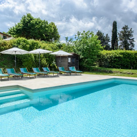 Relax in the sun next to the Tuscan travertine infinity pool