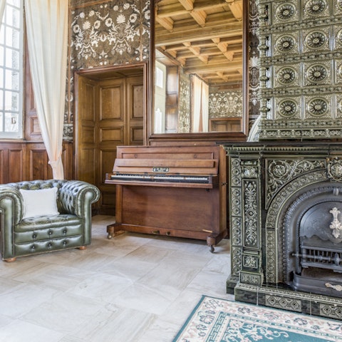 Tickle the ivories on the upright piano in the salon