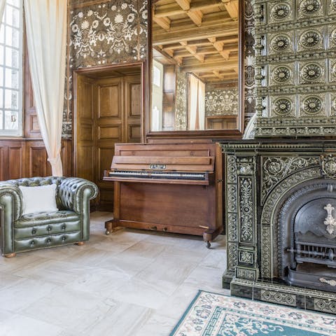 Tickle the ivories on the upright piano in the salon