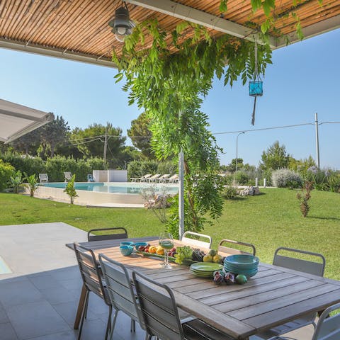 Dine alfresco under the vine covered purgola in the garden
