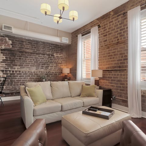 Relax on the sofa in the loft-like living room, with its exposed brick walls
