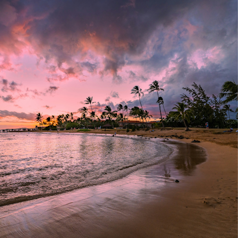 Watch the sunset over the horizon at Poipu beach, a short drive away