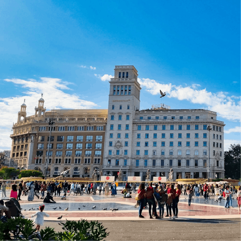People watch in Plaça de Catalunya, a short walk away