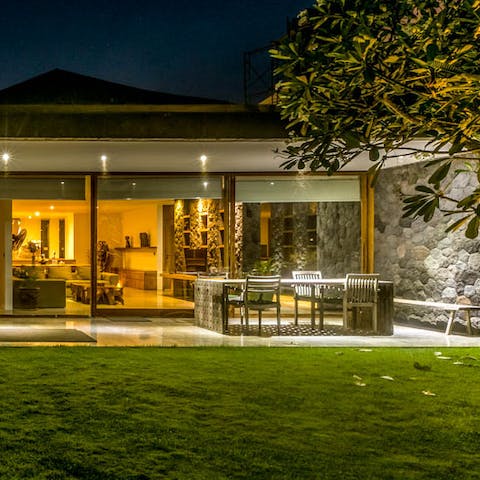 Gather around the outdoor dining table for drinks and card games, listening to the sounds of the tropics
