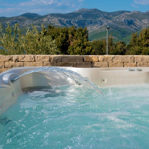 Unwind in the hot tub as the sun goes does