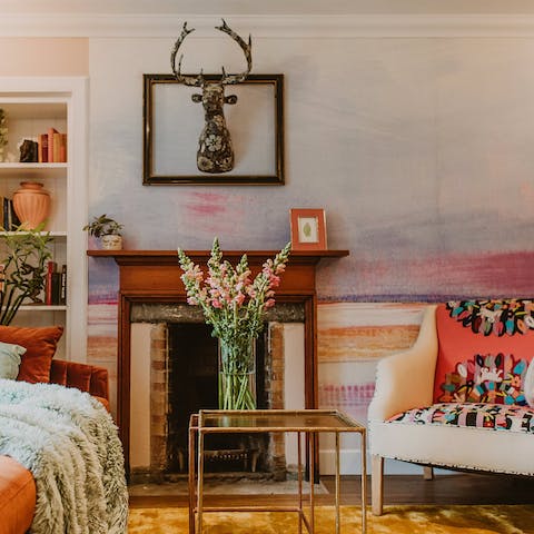 Cosy up in front of the fireplace on the crewelwork-embroidered, deep-set arm chair