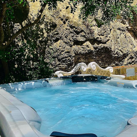 Unwind in the private hot tub before the blue seascape