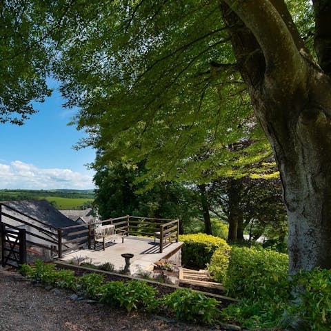 Step outside and bask in the beauty of this setting from a seat under the trees