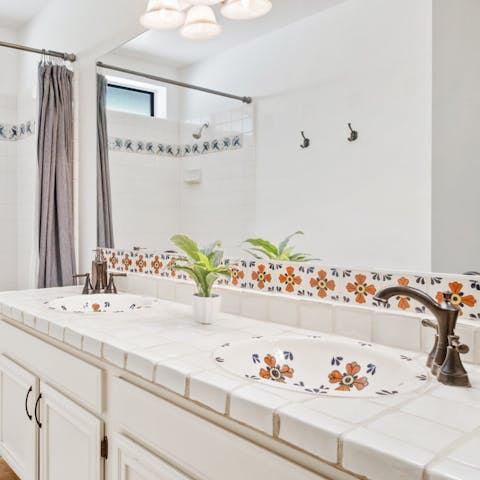 Admire the ornate, vintage tiles and ceramic sink in the bathroom