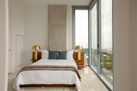 Wake to sweeping city and waterfront views from bed