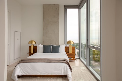Wake to sweeping city and waterfront views from bed