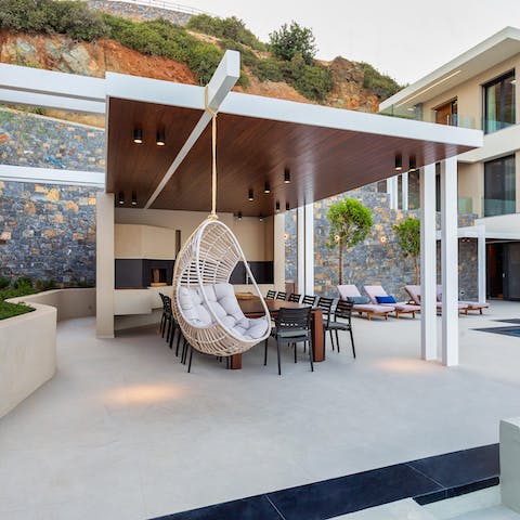 Relax in the swinging egg chair by the outdoor kitchen while taking in the seascape