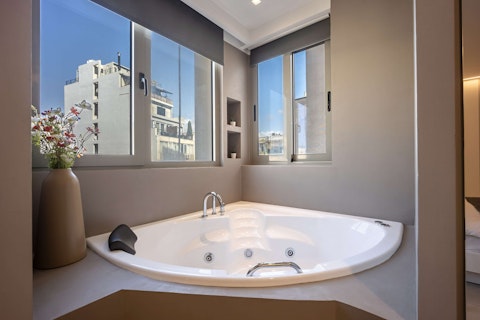 Unwind in the Jacuzzi bathtub as Athens light pours in