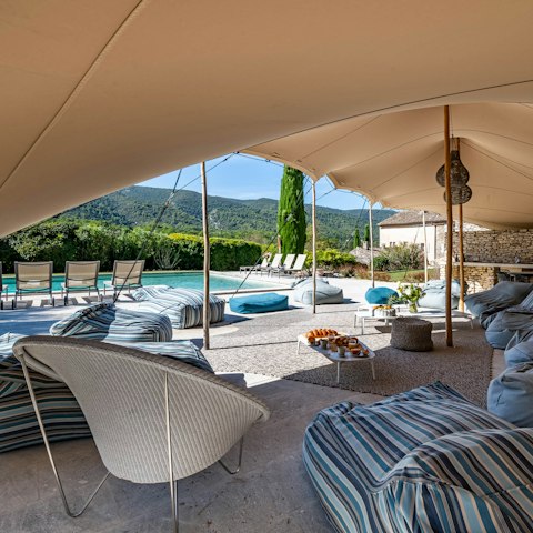 Relax poolside on a bean bag chair under a large shade sail