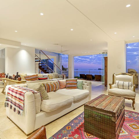 Gather in your sumptuous living area with the retractable glass wall fully open to allow the sea breeze to drift in