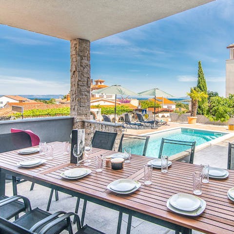 Share alfresco meals on the terrace with a view of the sea in the distance
