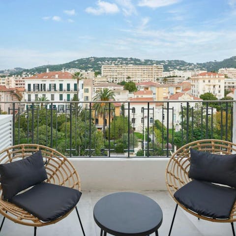 Take in the views over the palm trees and the city from the balcony