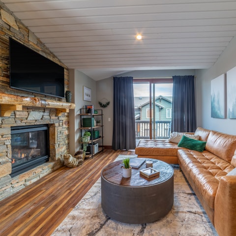 Sink into the leather sofa beside a roaring stone fireplace