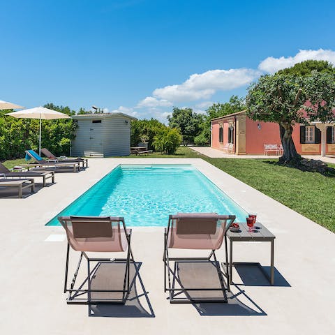 Slip into the swimming pool before unwinding with a cocktail on the sun loungers