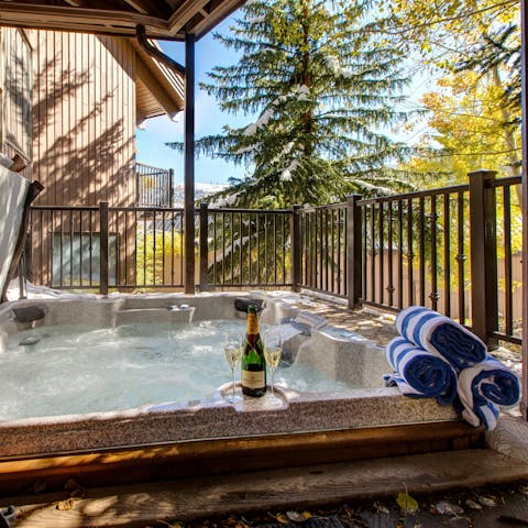 Soak in the hot tub with a glass of bubbly