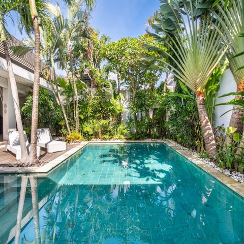 Float in the pool surrounded by lush greenery