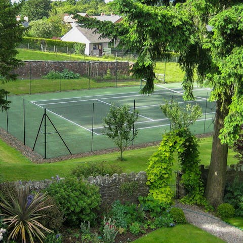 Have a tennis match shaded by the garden's trees