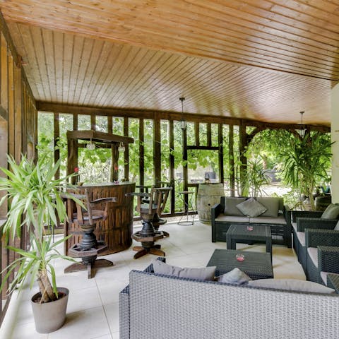 Mix cocktails at the bar under the covered veranda