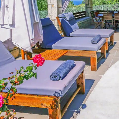 Relax on the comfy loungers by the poolside