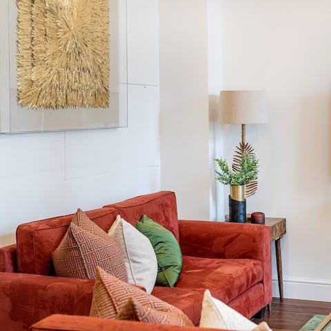 Relax and unwind on the red velvet sofas in the living area