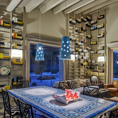 Gather together for a meal at the dining table surrounded by ceiling-high shelves of books