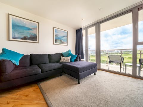 Cosy up in the light-filled living area as waves lap beyond