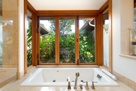 Bathe surrounded by lush tropical greenery just beyond the glass