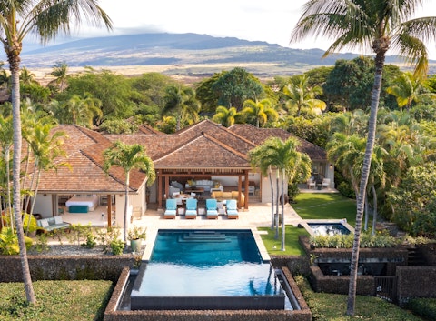 Cool off in the pool framed by palms and volcano views