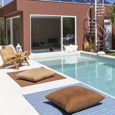 Get comfy next to the swimming pool while you dip your feet in the water