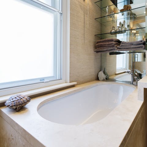 Close your eyes and relax in the master bathroom's sleek bathtub