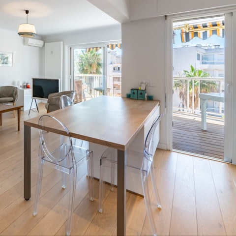 Enjoy a meal at the dining table with the balcony beyond
