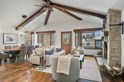 Gather round a stone fireplace beneath soaring timber beams