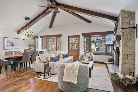 Gather round a stone fireplace beneath soaring timber beams