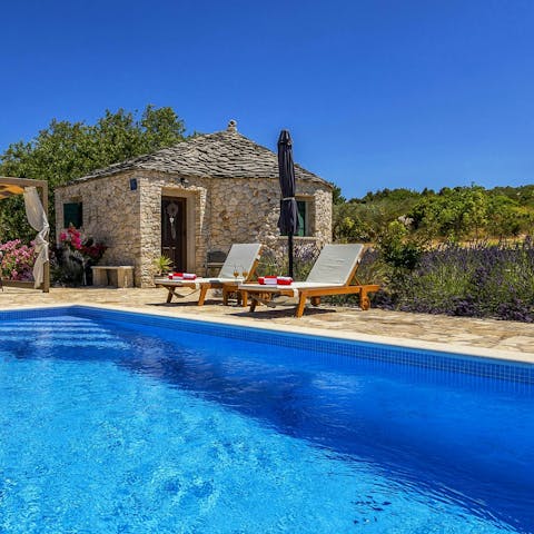 Recline in the sunshine by the private pool