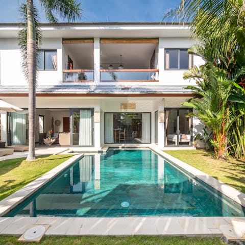 Take a refreshing dip in the pool surrounded by tropical plants