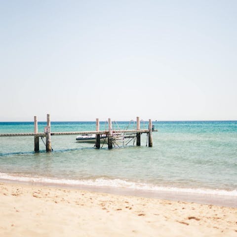 Dip your toes into the crystal clear sea at the golden sandy Praia de Ofir
