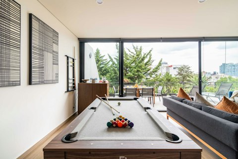 Challenge your fellow guests to a game of pool with the city skyline beyond