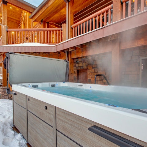Unwind in the large hot tub while taking in mountain views