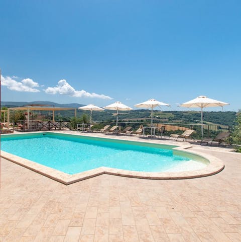 Stretch out by the pool with views across rolling countryside