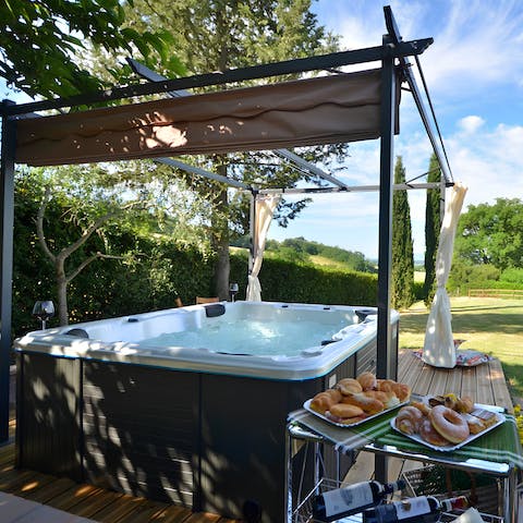 Relax in the private outdoor hot tub, complete with curtains for privacy