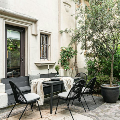 Share a bottle of wine around the table in the courtyard
