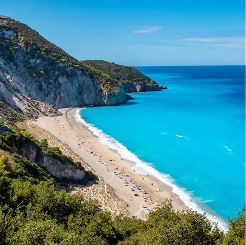 Swim in the turquoise waters of the cliff-backed Mylos Beach